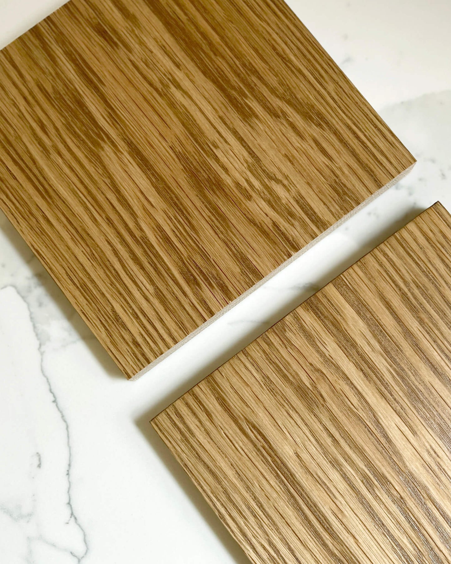 Two wooden oak stain samples on a marble surface